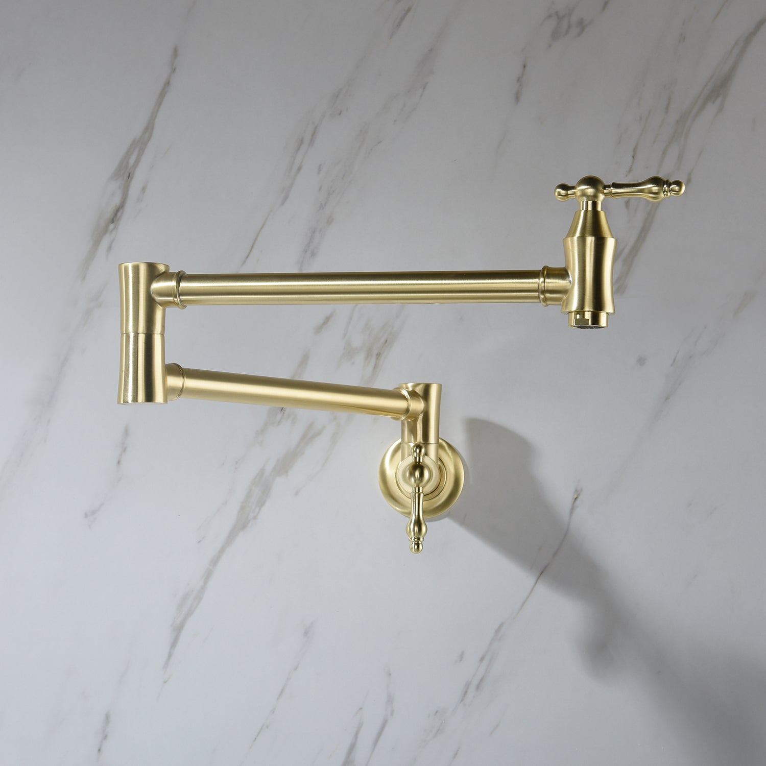 Gold kitchen faucet on a marble wall